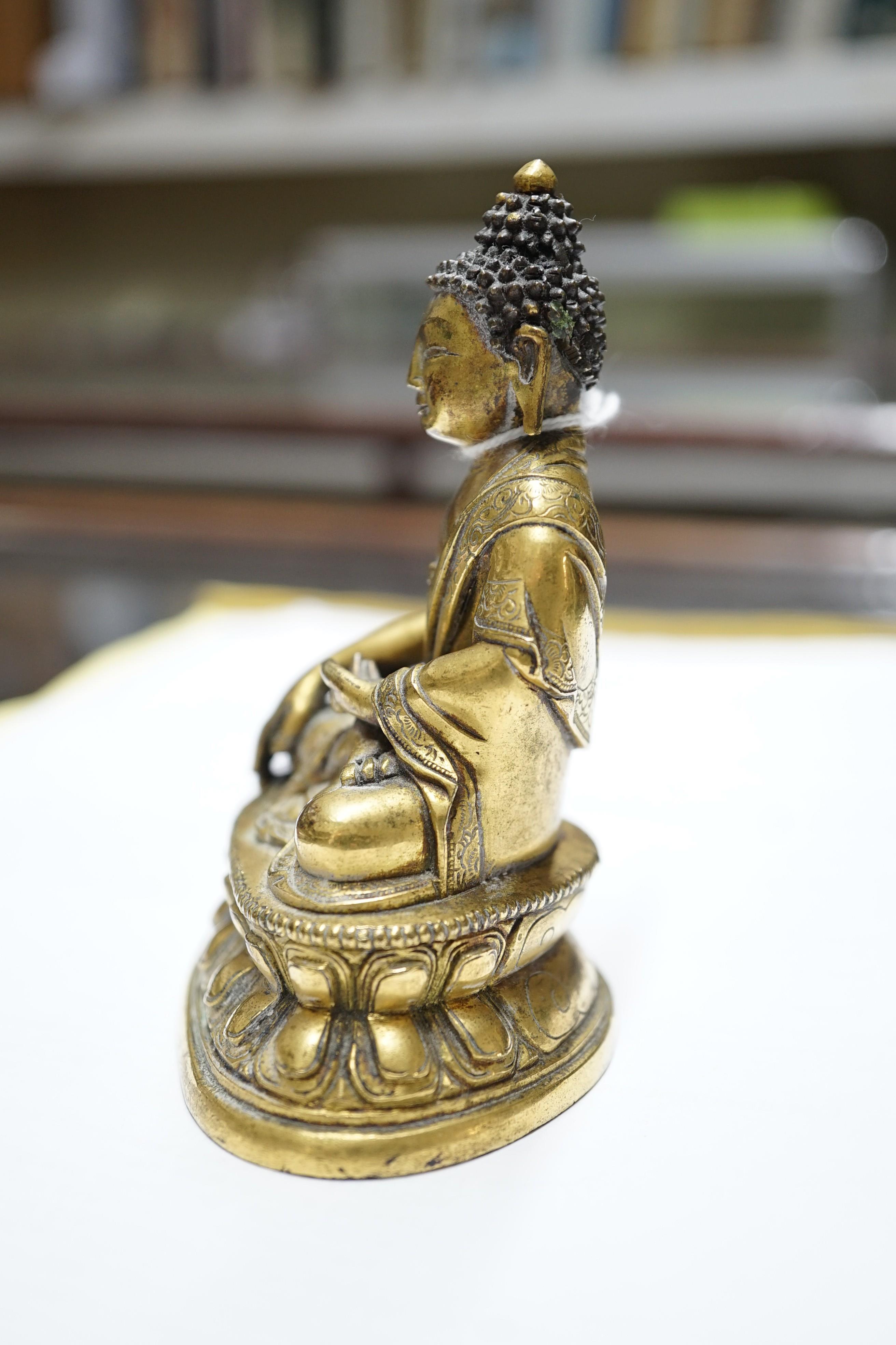 A small Tibetan gilt bronze seated figure of Buddha Shakyamuni, 18th century, 9.5cm high, lacking bowl in left hand